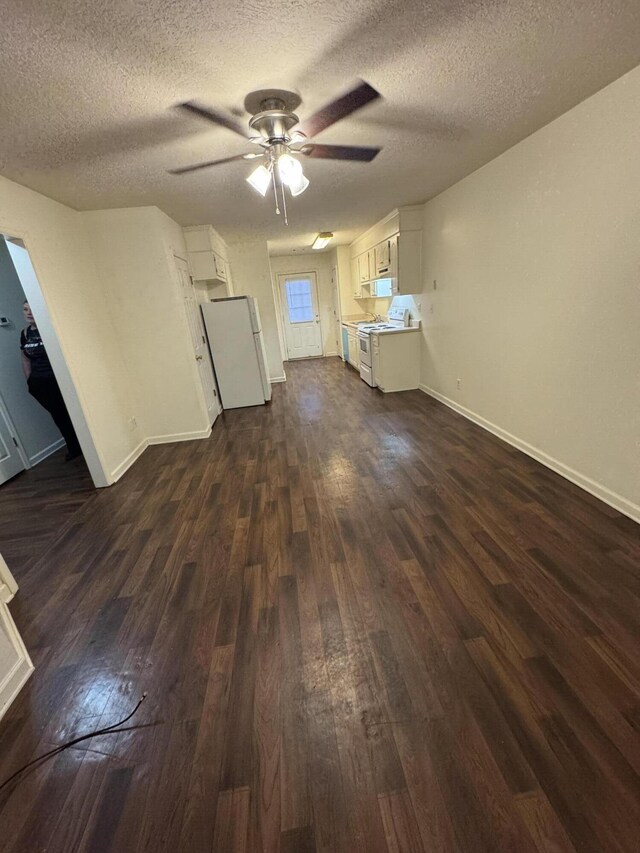 unfurnished living room with ceiling fan, dark hardwood / wood-style flooring, and a textured ceiling