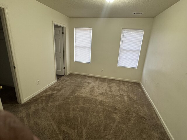 carpeted spare room with a textured ceiling