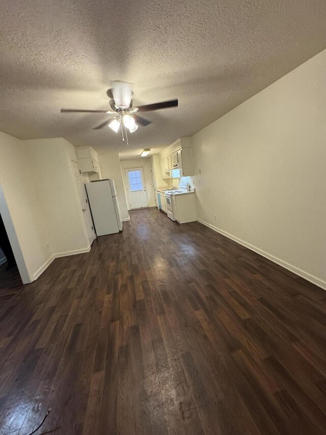 unfurnished living room with a textured ceiling, dark hardwood / wood-style floors, and ceiling fan