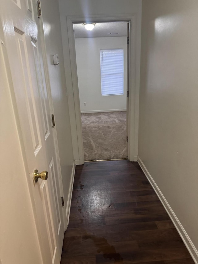 corridor with dark hardwood / wood-style flooring