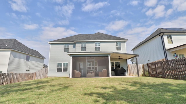 back of house with a fenced backyard, a ceiling fan, a sunroom, and a yard