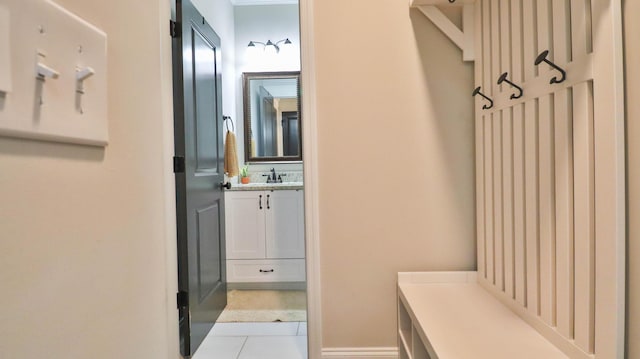 mudroom featuring light tile patterned flooring and a sink