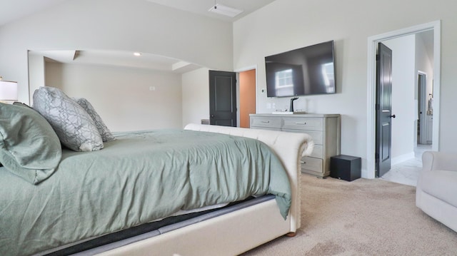 bedroom featuring arched walkways, light carpet, and ensuite bath