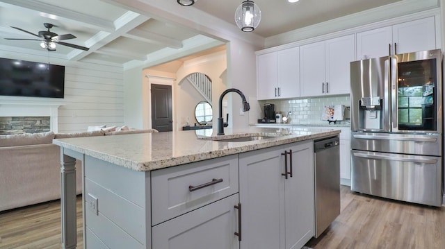 kitchen featuring a sink, light wood-style flooring, appliances with stainless steel finishes, and open floor plan