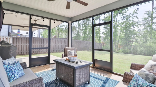 sunroom featuring ceiling fan, an outdoor living space, and a wealth of natural light