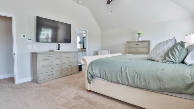 bedroom featuring a ceiling fan, baseboards, lofted ceiling, ensuite bathroom, and light carpet