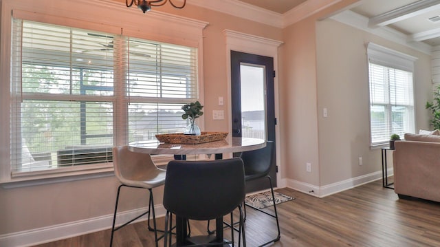 dining room with baseboards, wood finished floors, beamed ceiling, visible vents, and ornamental molding