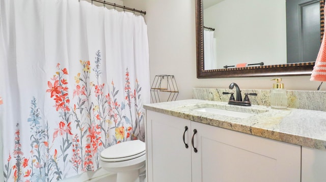bathroom with toilet, a shower with shower curtain, and vanity