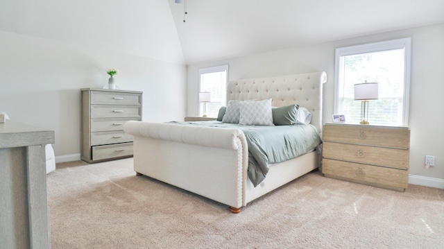 bedroom featuring baseboards, lofted ceiling, and light carpet