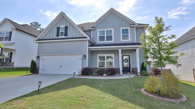 craftsman-style home featuring an attached garage, a front lawn, stone siding, board and batten siding, and concrete driveway