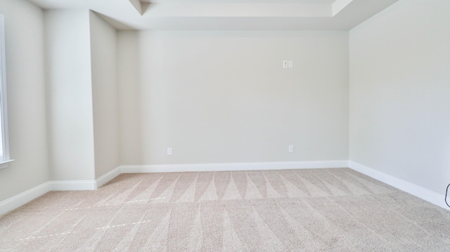 carpeted empty room featuring baseboards