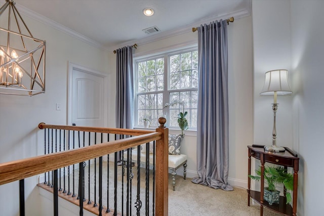 interior space featuring visible vents, baseboards, ornamental molding, an upstairs landing, and an inviting chandelier