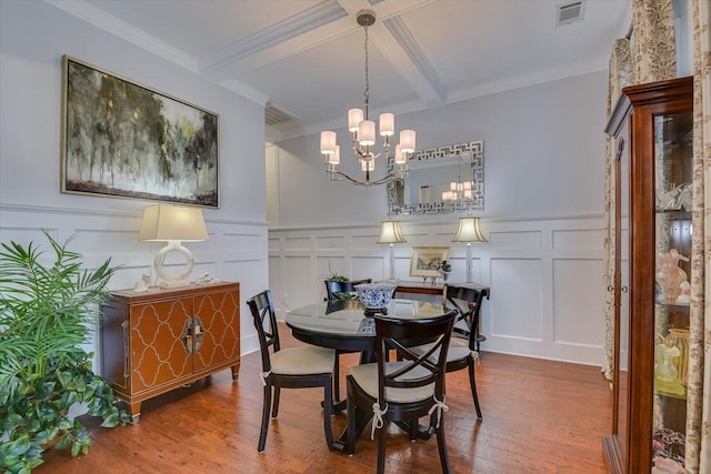 dining area featuring visible vents, beam ceiling, a notable chandelier, and wood finished floors