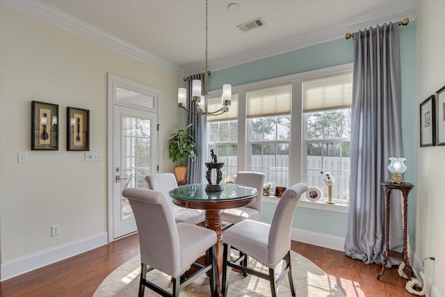 dining space with visible vents, baseboards, ornamental molding, an inviting chandelier, and wood finished floors