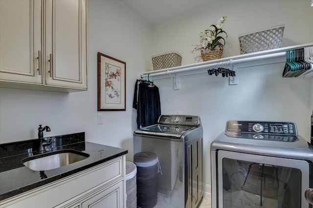 washroom with a sink, cabinet space, and independent washer and dryer