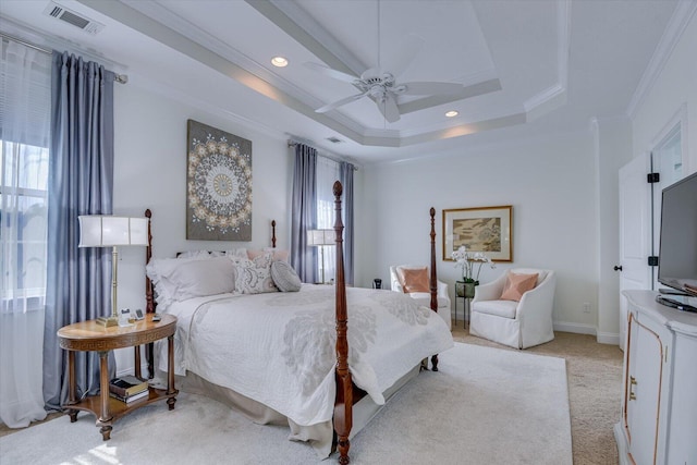 bedroom featuring a raised ceiling, crown molding, visible vents, and light carpet