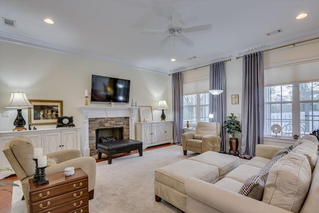 living area featuring crown molding, visible vents, a wealth of natural light, and ceiling fan