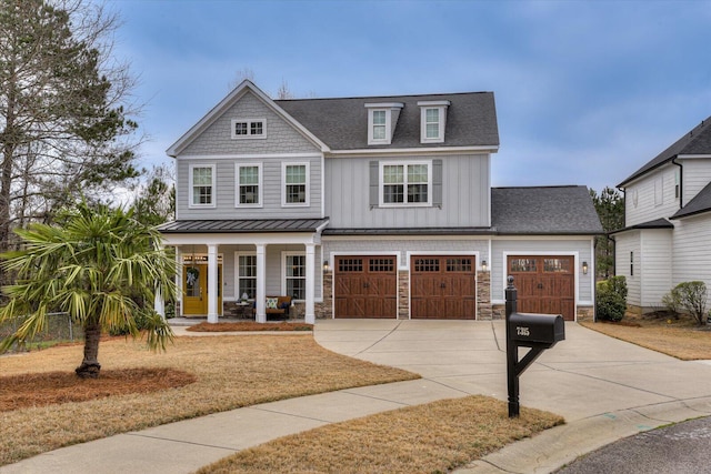 view of front facade with driveway, a porch, an attached garage, a shingled roof, and board and batten siding