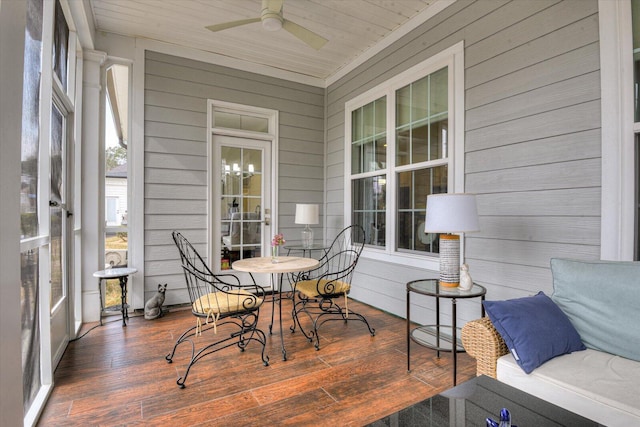 sunroom featuring wood ceiling and a ceiling fan