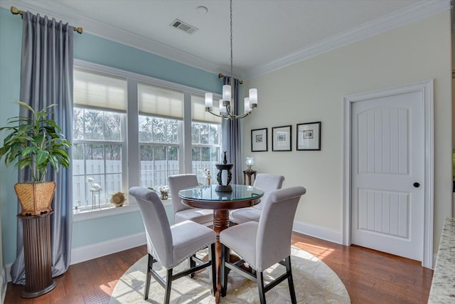 dining room featuring wood finished floors, baseboards, visible vents, an inviting chandelier, and ornamental molding