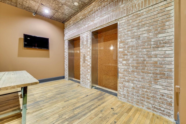 hall with elevator and hardwood / wood-style flooring