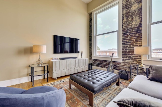 living room featuring light hardwood / wood-style flooring and brick wall