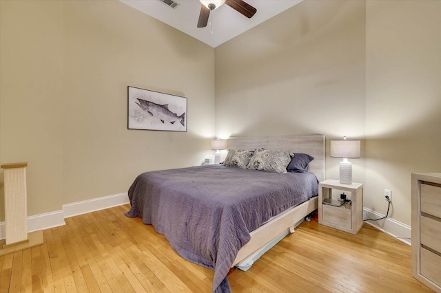 bedroom with ceiling fan, vaulted ceiling, and light hardwood / wood-style flooring