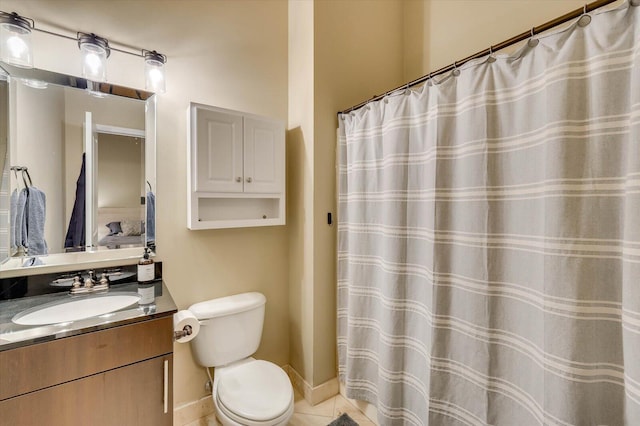 bathroom with tile patterned flooring, vanity, and toilet