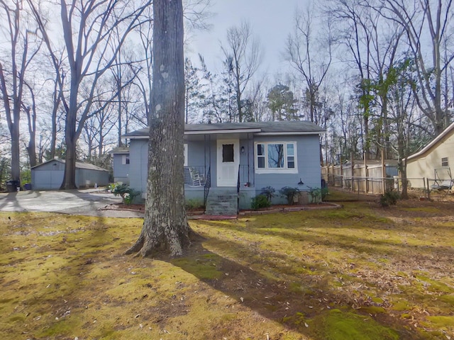 view of front of home with an outbuilding, a garage, and a front yard