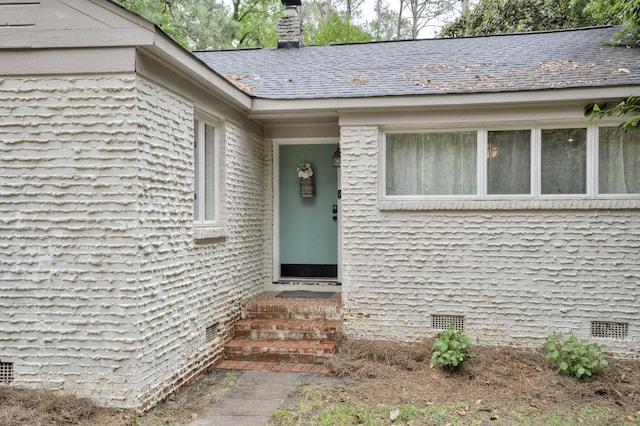 entrance to property featuring a chimney and crawl space