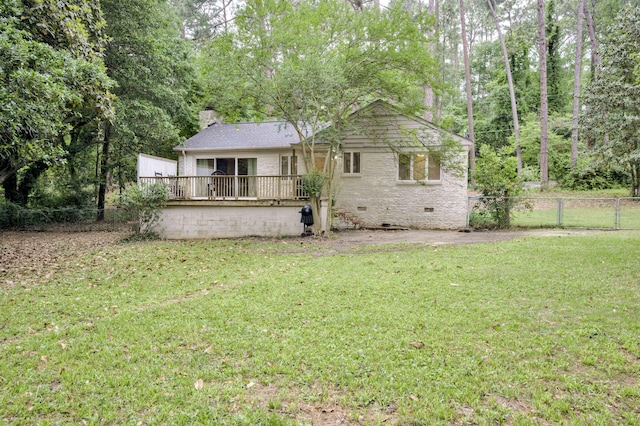 back of property featuring crawl space, a deck, brick siding, and a chimney