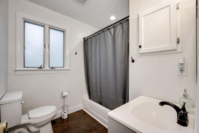 bathroom with toilet, wood finished floors, baseboards, crown molding, and a sink