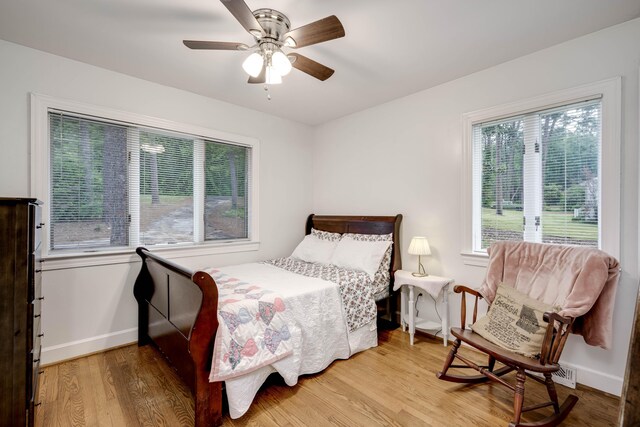 bedroom with wood finished floors, baseboards, and ceiling fan
