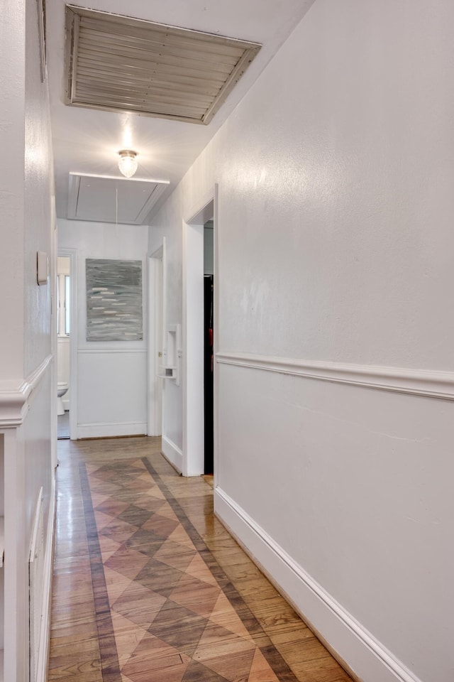 corridor featuring attic access and baseboards