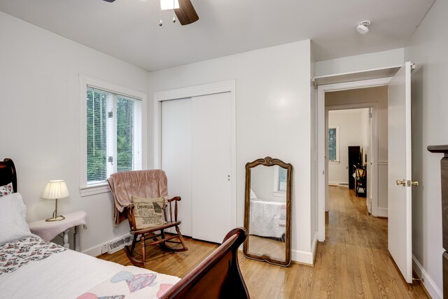bedroom featuring light wood-type flooring, a closet, a ceiling fan, and baseboards