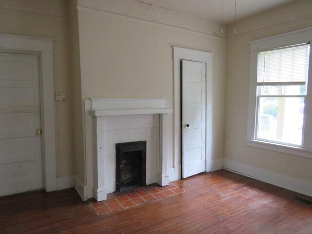 1307 Beman St, Augusta, GA 30904 - unfurnished living room featuring wood finished floors and a fireplace with raised hearth