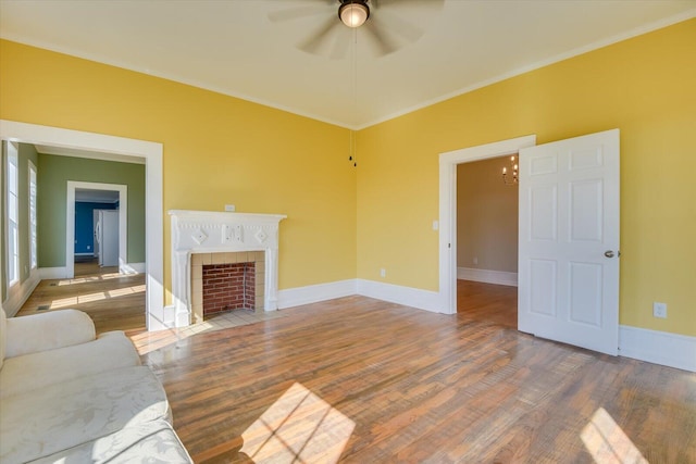 unfurnished living room with ceiling fan with notable chandelier, hardwood / wood-style flooring, and crown molding