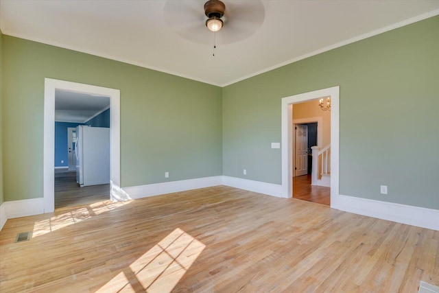 unfurnished room featuring light hardwood / wood-style floors, ceiling fan with notable chandelier, and ornamental molding