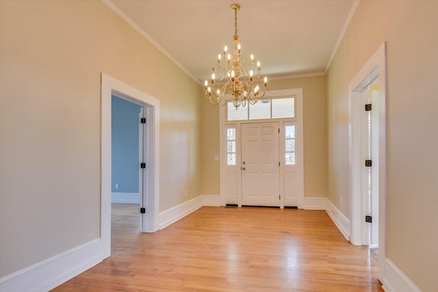 foyer entrance featuring light hardwood / wood-style flooring, crown molding, and a notable chandelier