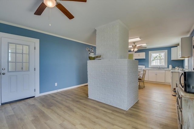 kitchen featuring white cabinetry, crown molding, ceiling fan, and light hardwood / wood-style flooring