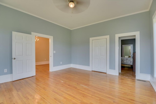 unfurnished bedroom featuring ceiling fan with notable chandelier, light hardwood / wood-style flooring, and crown molding