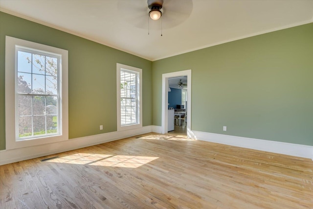 empty room with ceiling fan, crown molding, and light wood-type flooring