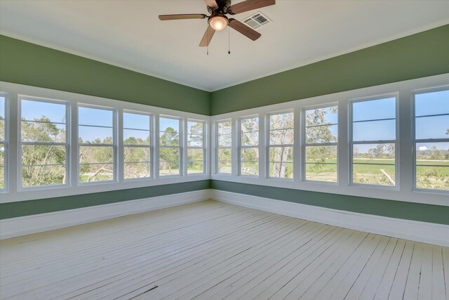 unfurnished sunroom featuring ceiling fan