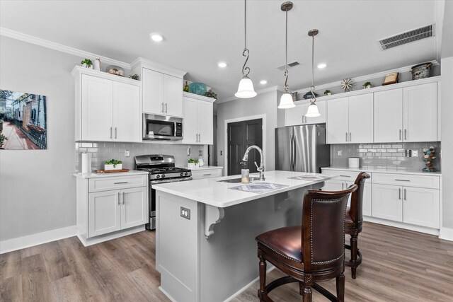 268 Anneswood Rd, Martinez, GA 30907 - kitchen featuring stainless steel appliances, a sink, wood finished floors, backsplash, and crown molding