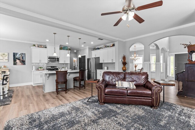 268 Anneswood Rd, Martinez, GA 30907 - living room featuring light wood-type flooring, arched walkways, a ceiling fan, ornamental molding, and a chandelier