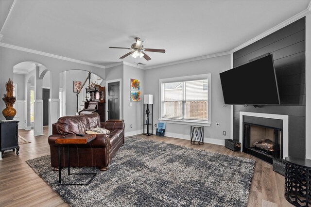 268 Anneswood Rd, Martinez, GA 30907 - living room featuring a ceiling fan, wood finished floors, a fireplace, crown molding, and arched walkways