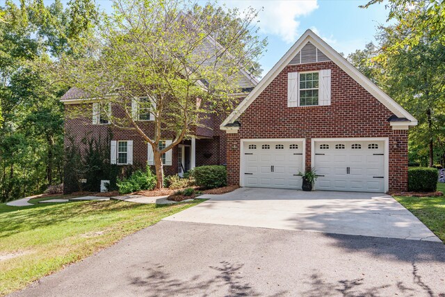 front facade with a garage and a front lawn