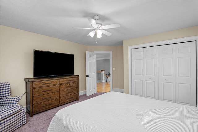 carpeted bedroom featuring ceiling fan and a closet