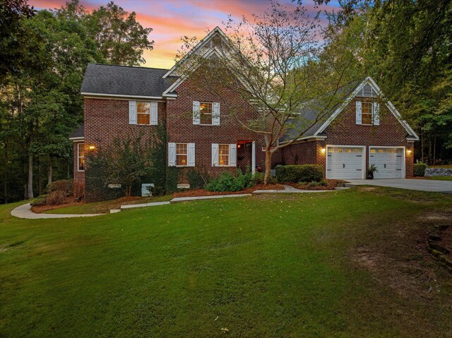 view of front of home featuring a garage and a yard