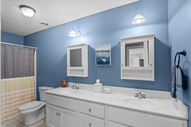 bathroom featuring tile patterned floors, walk in shower, vanity, a textured ceiling, and toilet